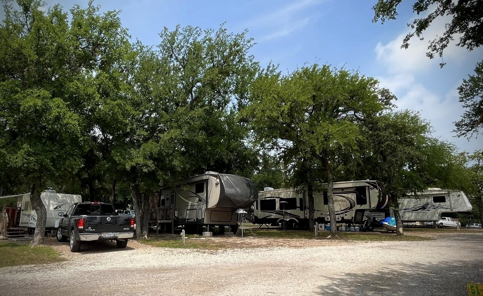 Fifth-wheel rigs parked among the oak trees at the ranch